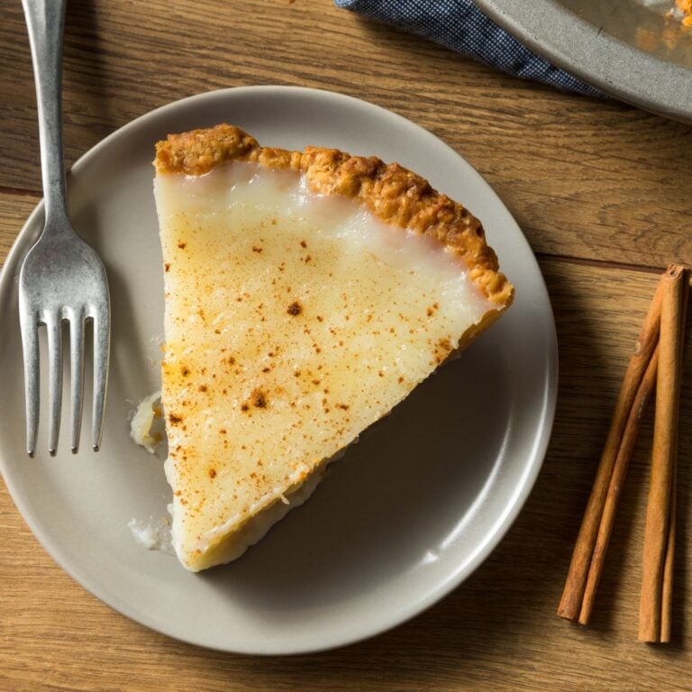 Overhead view of one slice of sugar cream pie on a plate with a fork