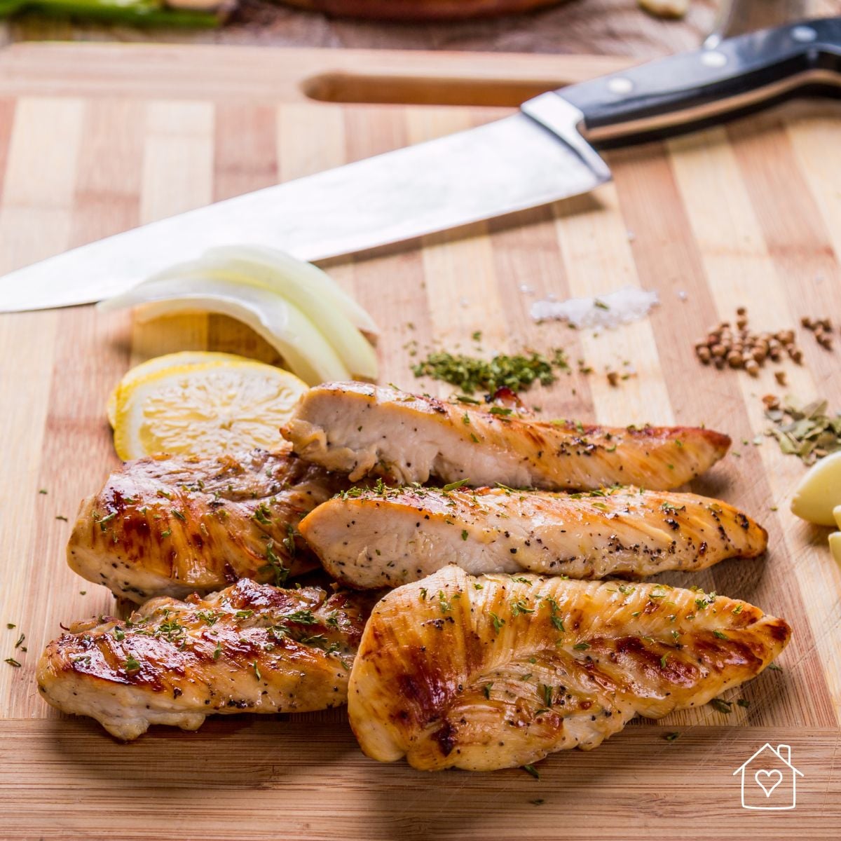 Grilled chicken breast strips sliced on a cutting board