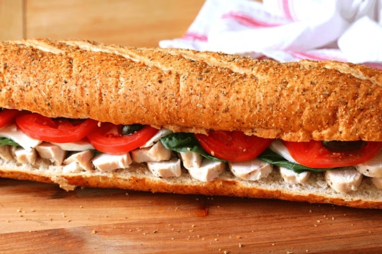 chicken hoagie layered with oven baked chicken, cheese, spinach, olives, tomatoes and more on a fresh hoagie bun