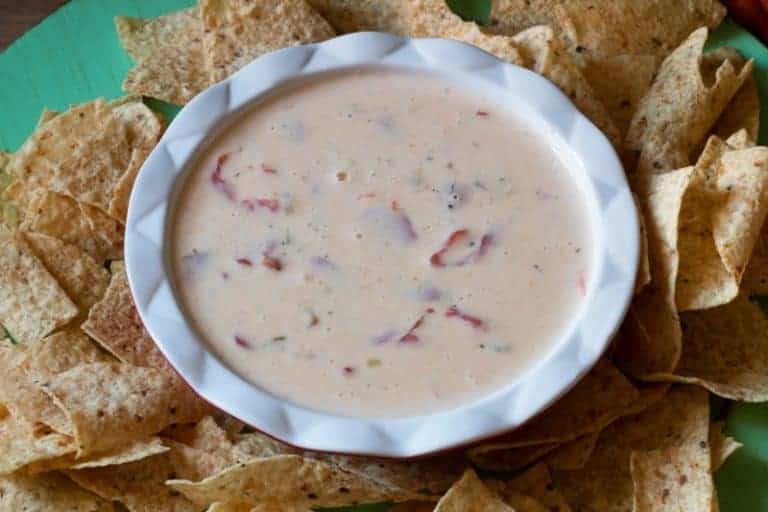 Slow Cooker Queso Blanco made with white American Cheese - can be made ahead and frozen. Creamy and delicious - get the recipe at www.cupcakesandcrinoline.com