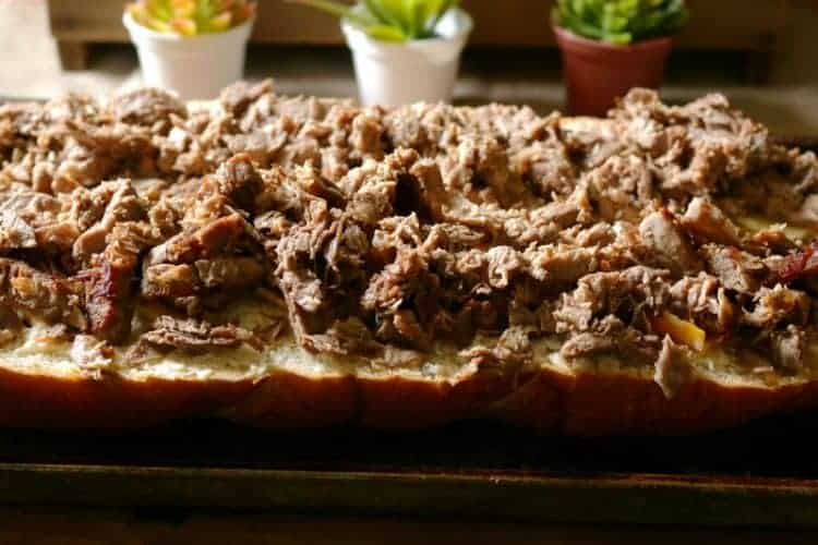 Fresh French bread, mayonnaise spread, and cooked steak on cookie sheet