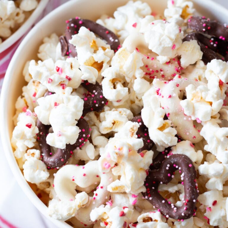 Closeup view of homemade popcorn with sprinkles and chocolate covered pretzels.