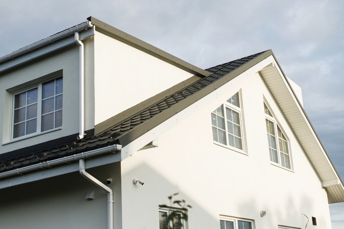 A stylish house exterior with fresh white paint, black trim, and a modern roof design, giving the home a clean and updated look.