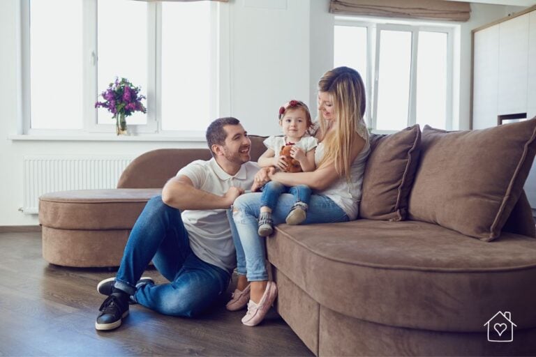 Happy young family relaxing together in their cozy living room, symbolizing a safe and healthy home environment.