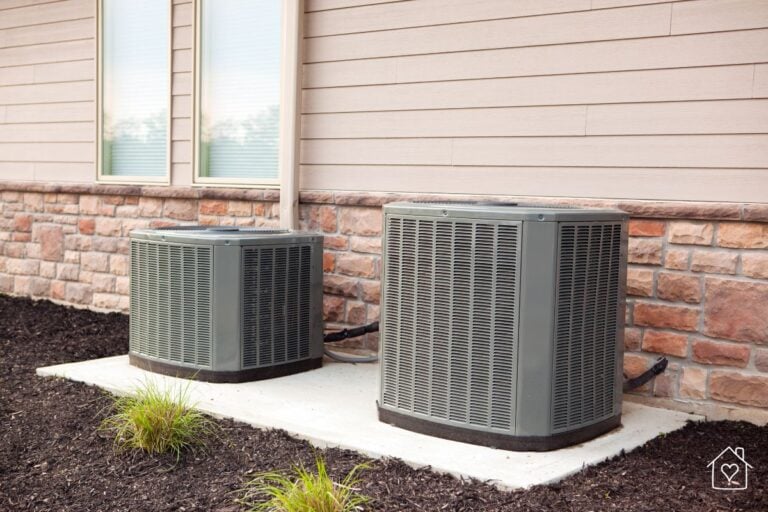 Two central air conditioning units outside a home, showcasing a well-maintained cooling system.