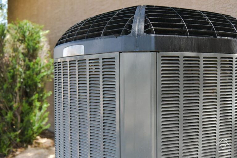 Close-up of a residential central air conditioning condenser unit with protective grill and side vents.