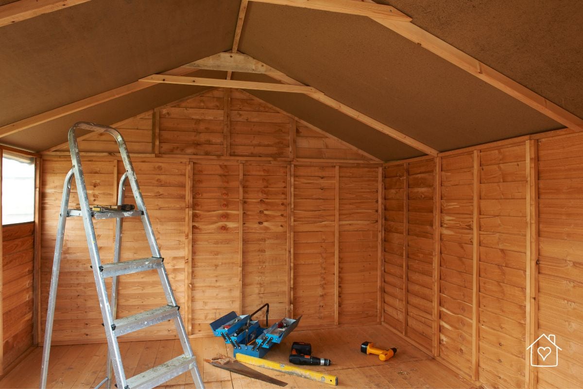 The interior of a wooden shed with tools and a ladder, ready for a DIY weekend improvement project.