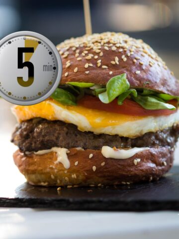 Juicy cheeseburger with egg, tomato, greens, and sesame bun, ready in 5 minutes