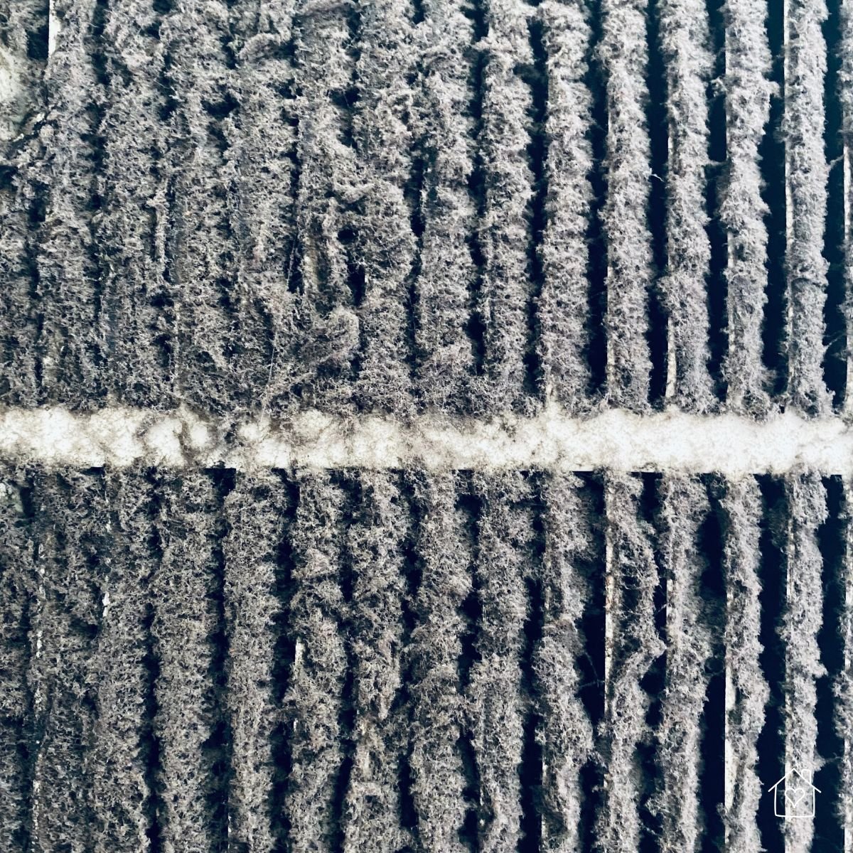 Heavily dust-covered air filter from an HVAC system, showing a common cause of AC failure and reduced airflow.