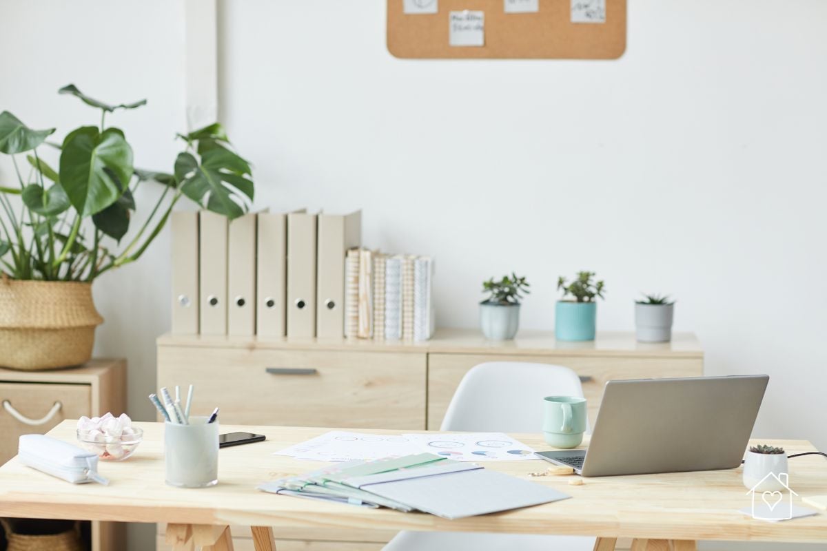 Light-filled home office with beige storage containers and plants, creating a clean and organized workspace.