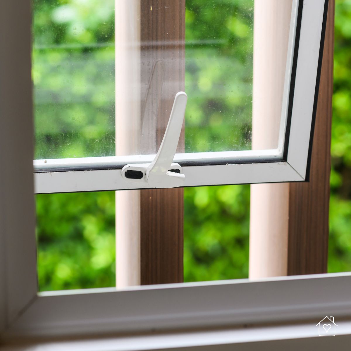 Tilted open window letting in fresh air and greenery from outside, a helpful tip for airflow when the air conditioner fails.
