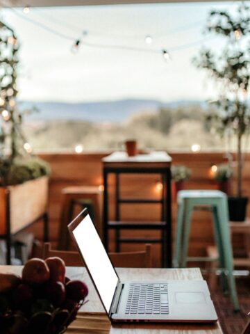 Cozy balcony workspace with twinkling lights and subtle storage containers for a serene remote work setup.