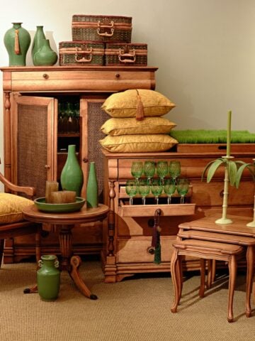 A vintage-themed room with ornate wooden furniture, green vases, and decorative pillows, showcasing elegant wood accents in your home design.