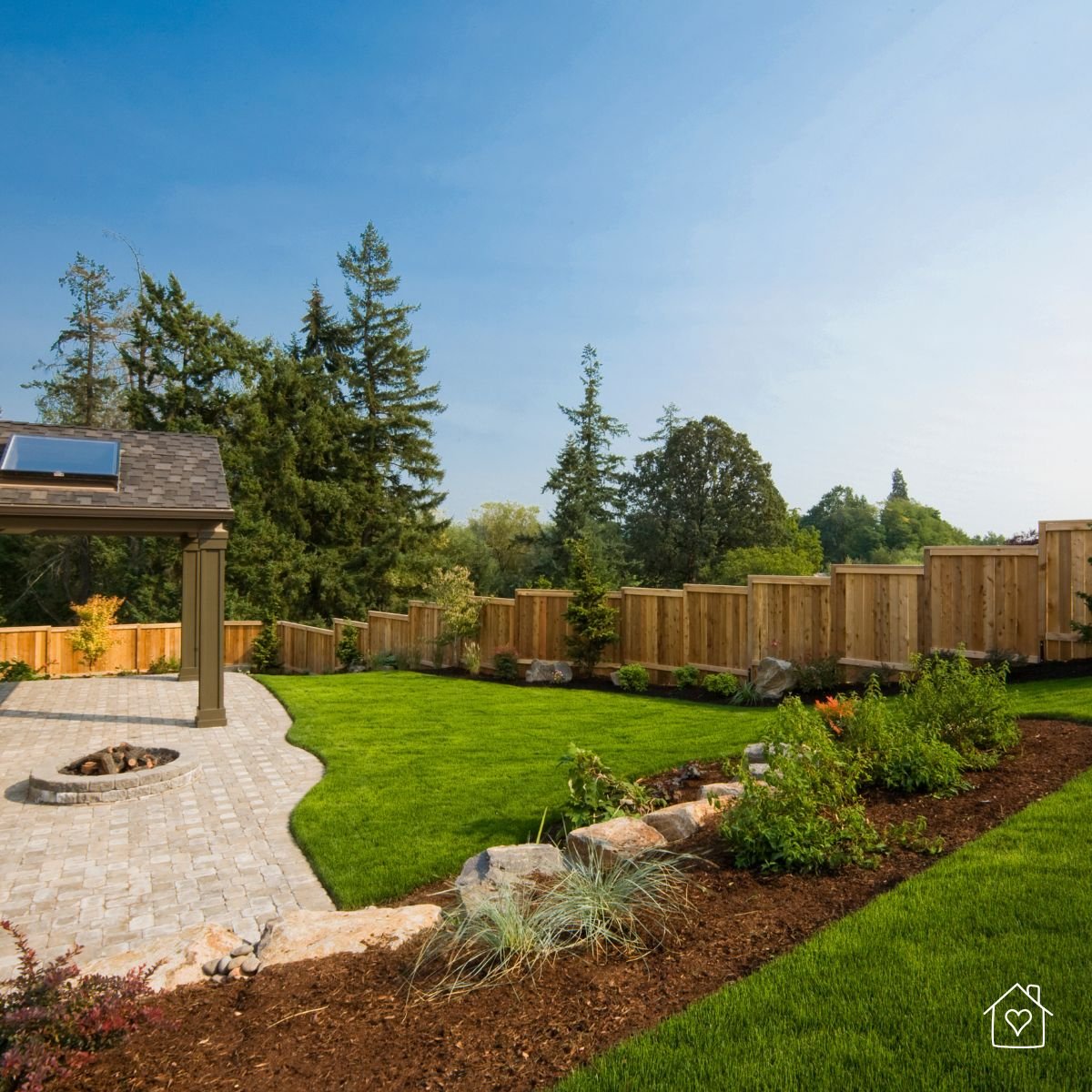 A beautiful backyard with fresh landscaping and fencing, highlighting potential hidden drainage issues beneath the surface.