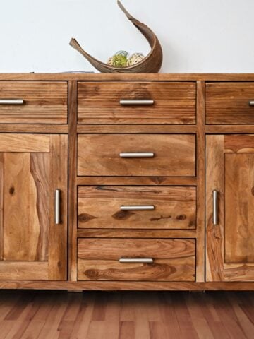 Close-up of a handcrafted sideboard made from reclaimed wood with metal handles, showcasing a rustic and eco-friendly furniture option.