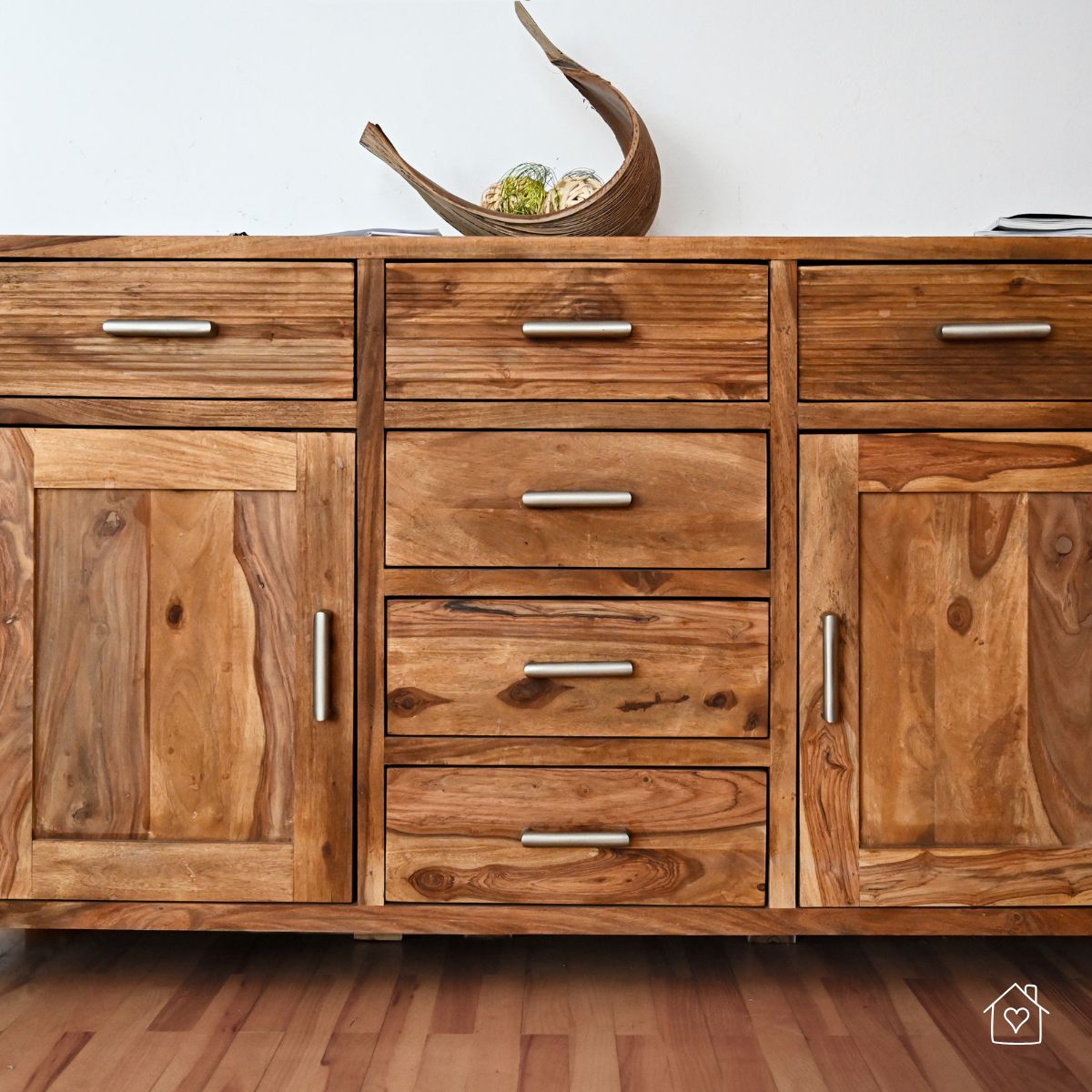 Close-up of a handcrafted sideboard made from reclaimed wood with metal handles, showcasing a rustic and eco-friendly furniture option.
