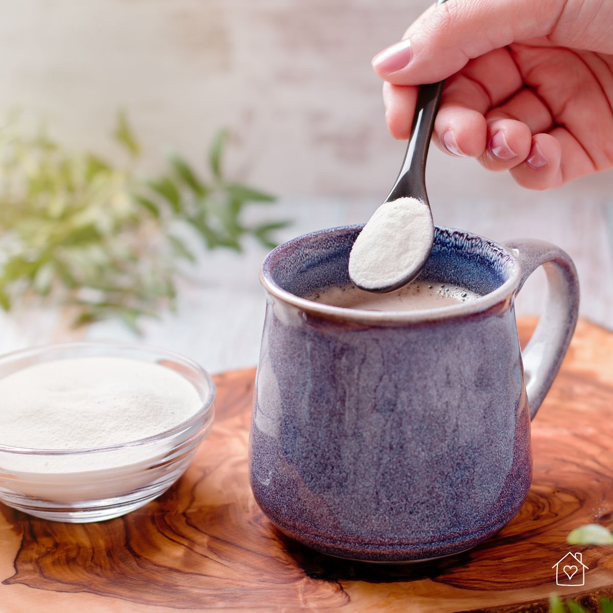 Hand scooping collagen powder into a cup of coffee as part of a daily skin care and anti-aging routine.