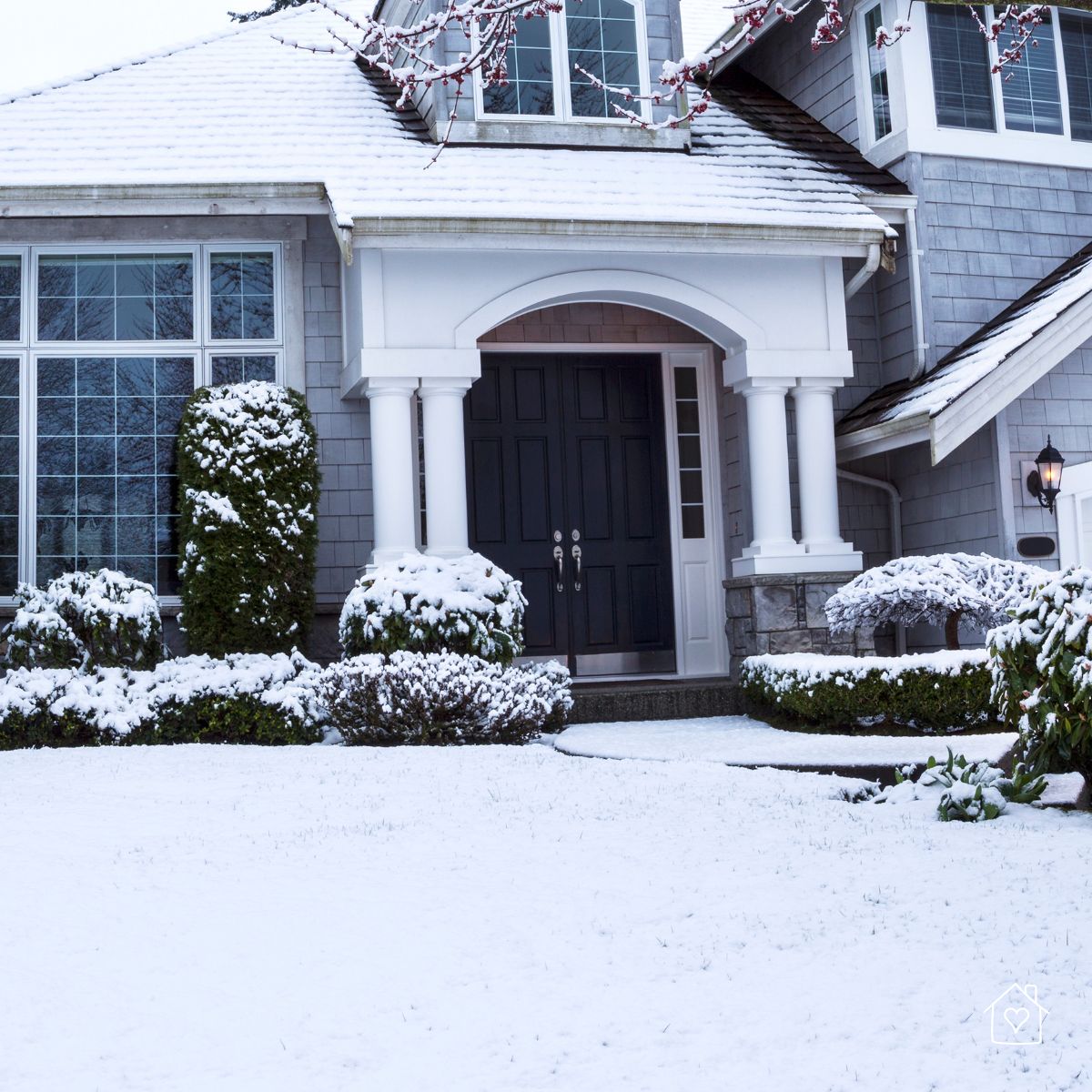 Front view of a home covered in snow, emphasizing the importance of winter weatherproofing.