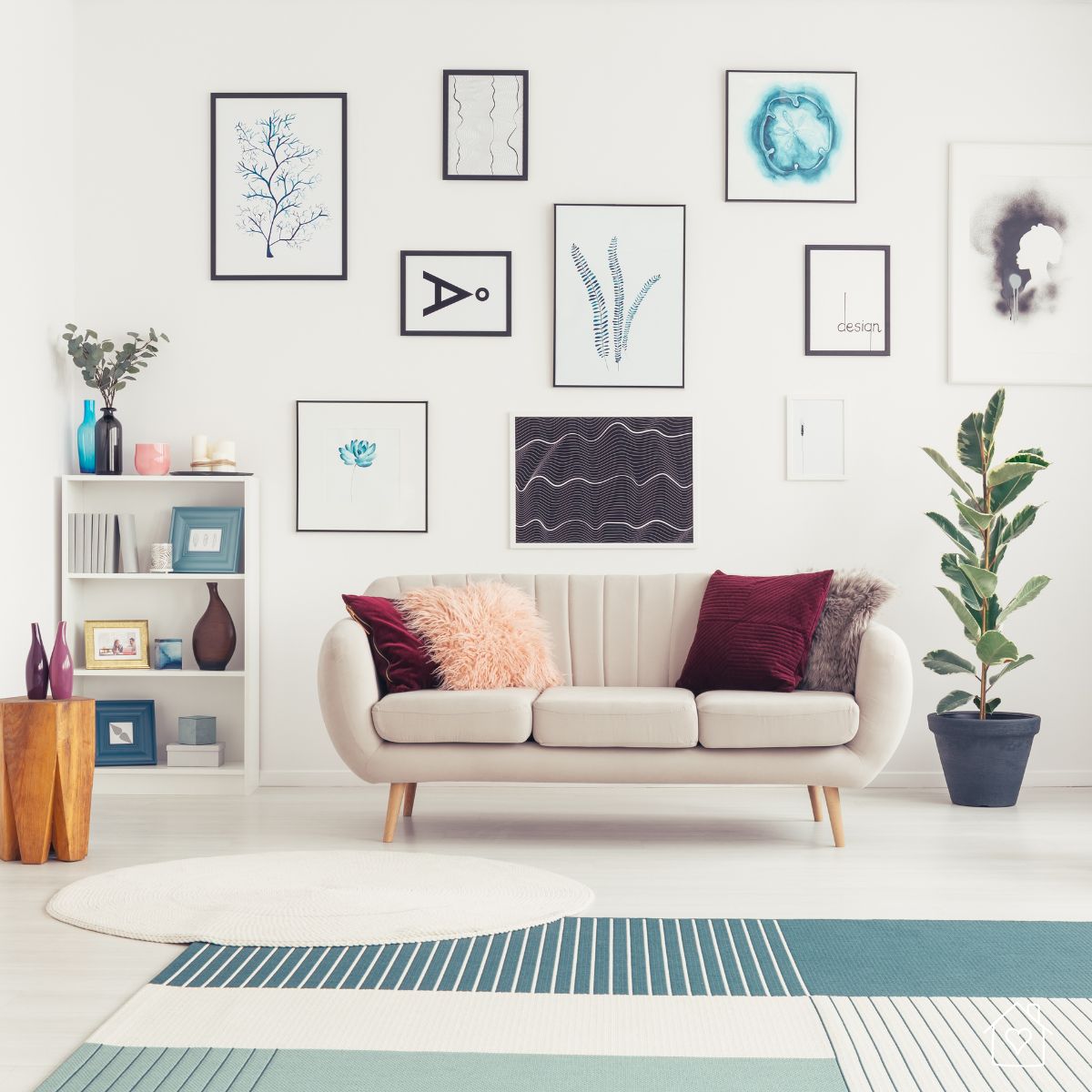 Modern living room with a beige sofa, colorful throw pillows, and a wall gallery of framed minimalist art