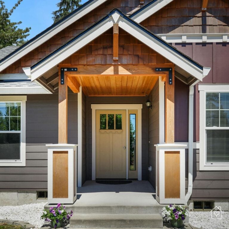 Neutral beige front door under a wooden gabled porch, showcasing a sheltered entryway built to withstand weather conditions.