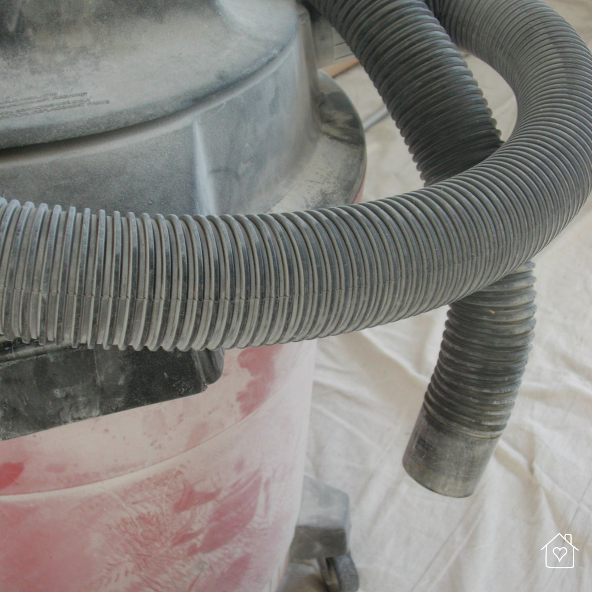 Close-up of a dusty shop vac hose, essential for cleaning up fine dust after renovation work is completed.