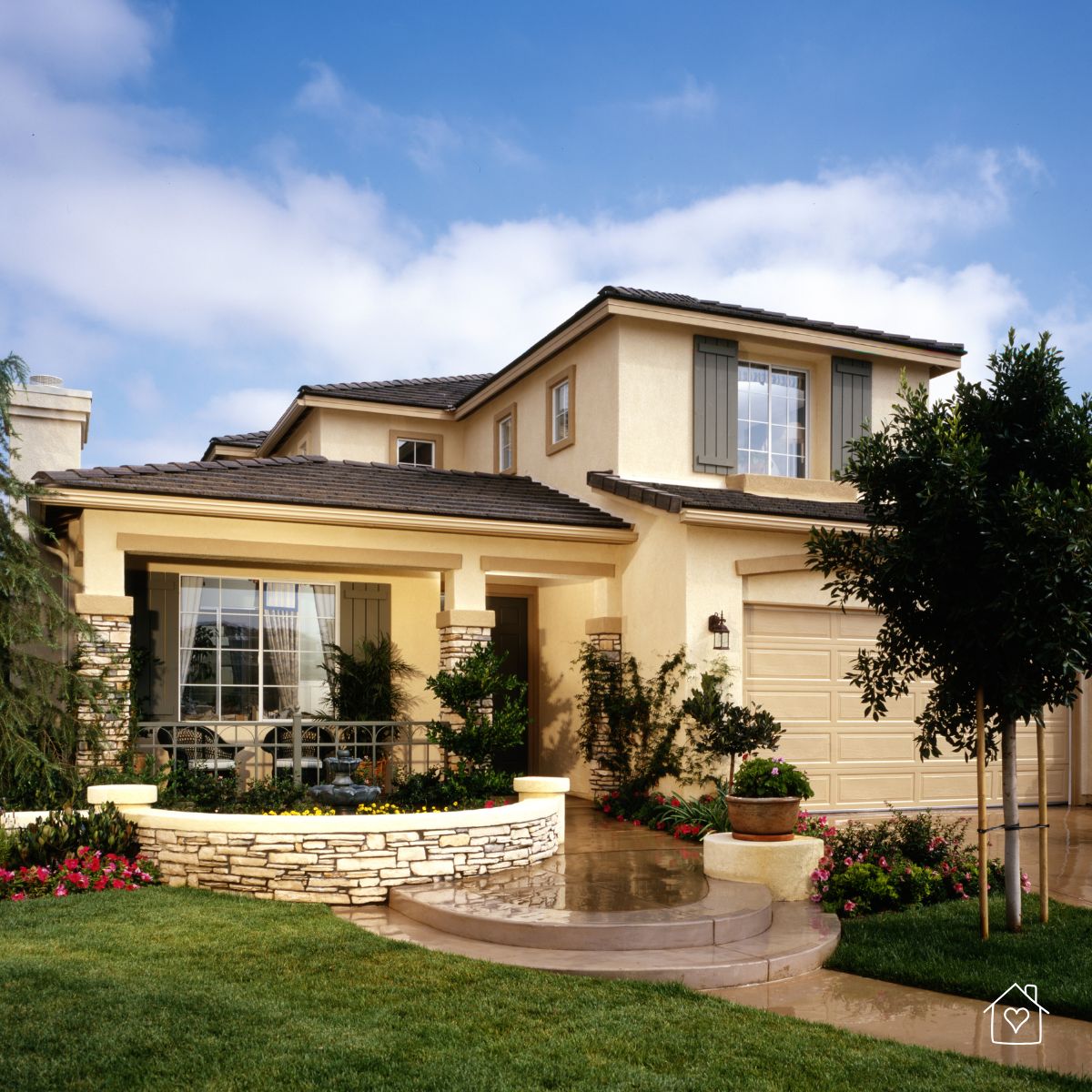 Stylish suburban home with stucco exterior and stone accents, designed for weather resistance.