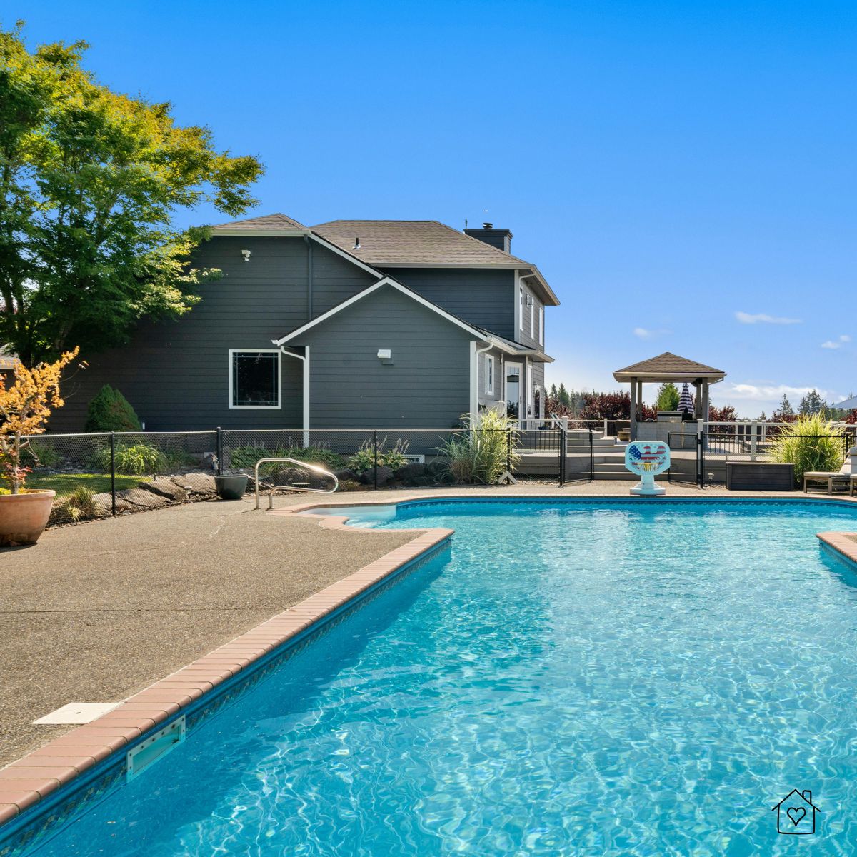 Large backyard pool with surrounding deck and gazebo, showcasing a safe and stylish pool area perfect for rubber decking installation.