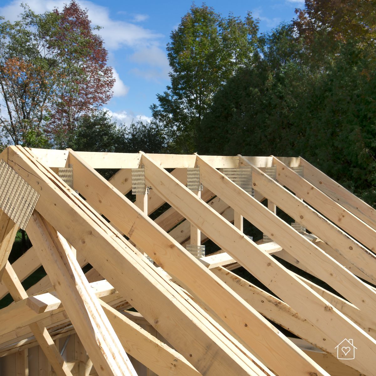 A detailed look at wooden roof trusses being installed on a home addition, showcasing the framing and metal connector plates.
