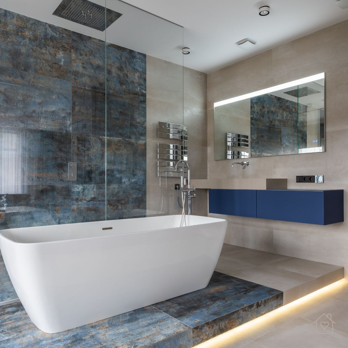Contemporary bathroom featuring a freestanding tub, textured stone walls, and bold blue cabinetry, a key interior design trend in Australia.