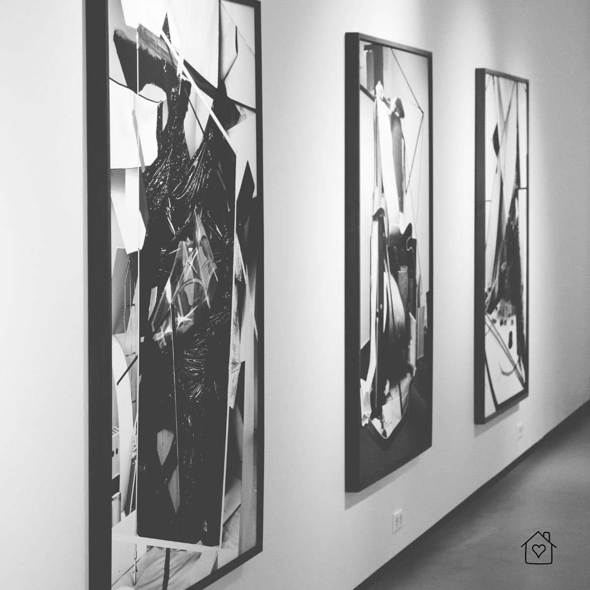 A series of framed black and white abstract paintings displayed along a modern gallery wall, highlighting the timeless appeal of monochrome art.