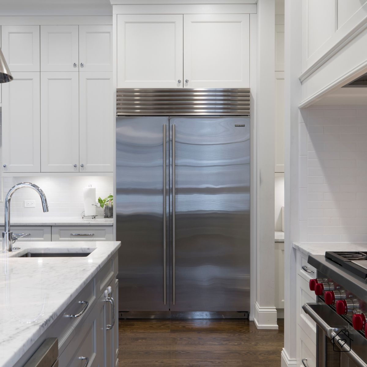 Bright white kitchen featuring stainless steel appliances and chrome cabinet hardware.