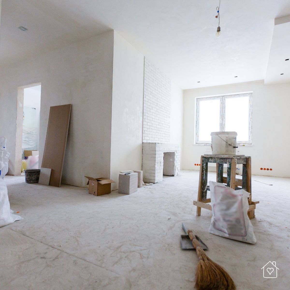 Renovation room with tools, drop cloths, and masked areas set up for clean, professional painting preparation.