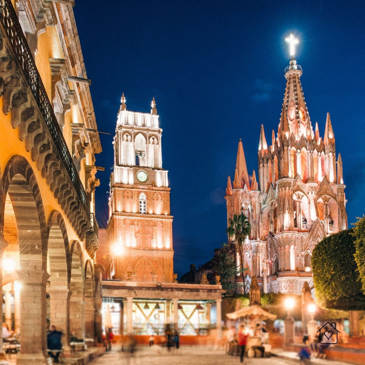 Night scene of La Parroquia de San Miguel Arcángel and the clock tower glowing over the main plaza in San Miguel de Allende, Mexico.
