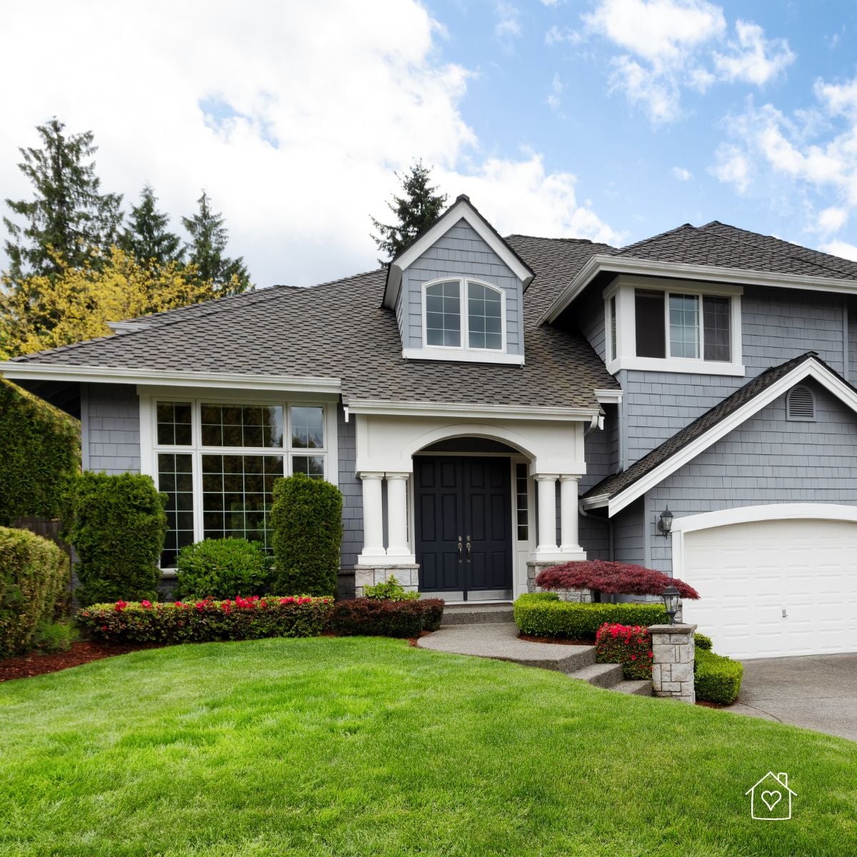 Front yard with neatly shaped shade trees and foundation plantings increasing curb appeal.