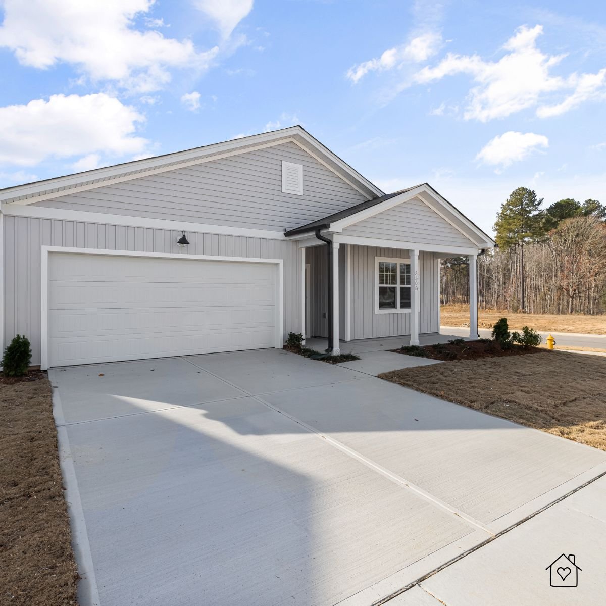 Freshly cleaned and sealed concrete driveway leading to a two-car garage, showing smooth joints and curb appeal.