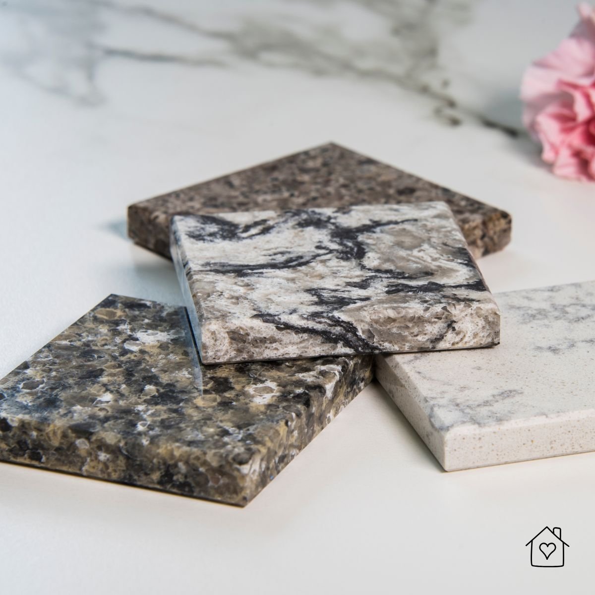 Close-up view of granite countertop samples in neutral gray and beige tones, showing natural patterns and texture for modern kitchen design inspiration.