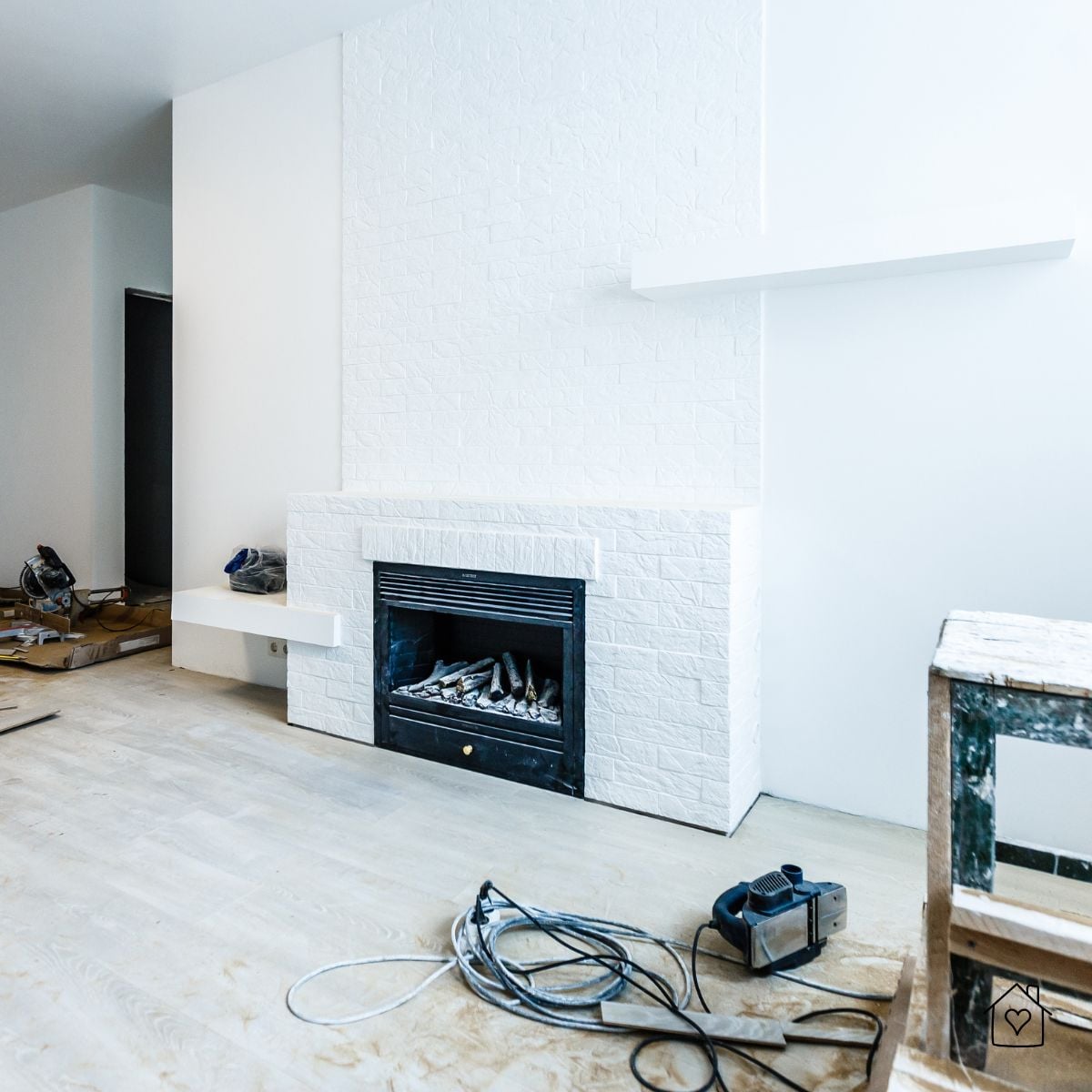 White brick fireplace under renovation in a Milwaukee home, showcasing modern updates and construction materials on site.