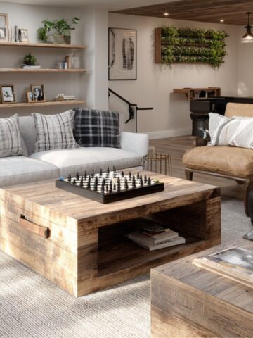 Cozy living room with neutral sofa, leather chair, rustic coffee table, open shelves and plants-quiet zone flooded with daylight.