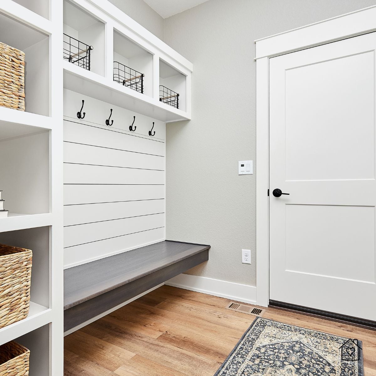 Bright mudroom with bench, shiplap wall, hooks, and storage baskets&mdash;organized entryway to keep muddy boots and winter gear contained.