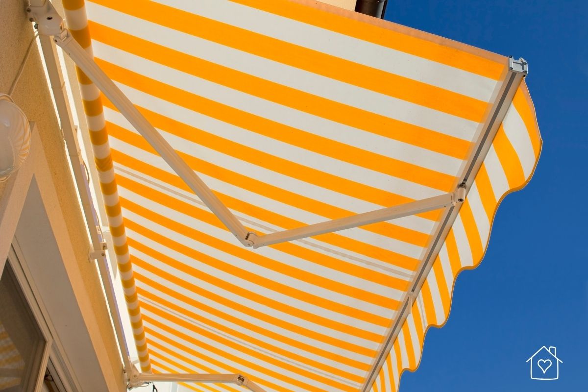 Yellow and white striped retractable awning showing fabric pattern and scalloped valance