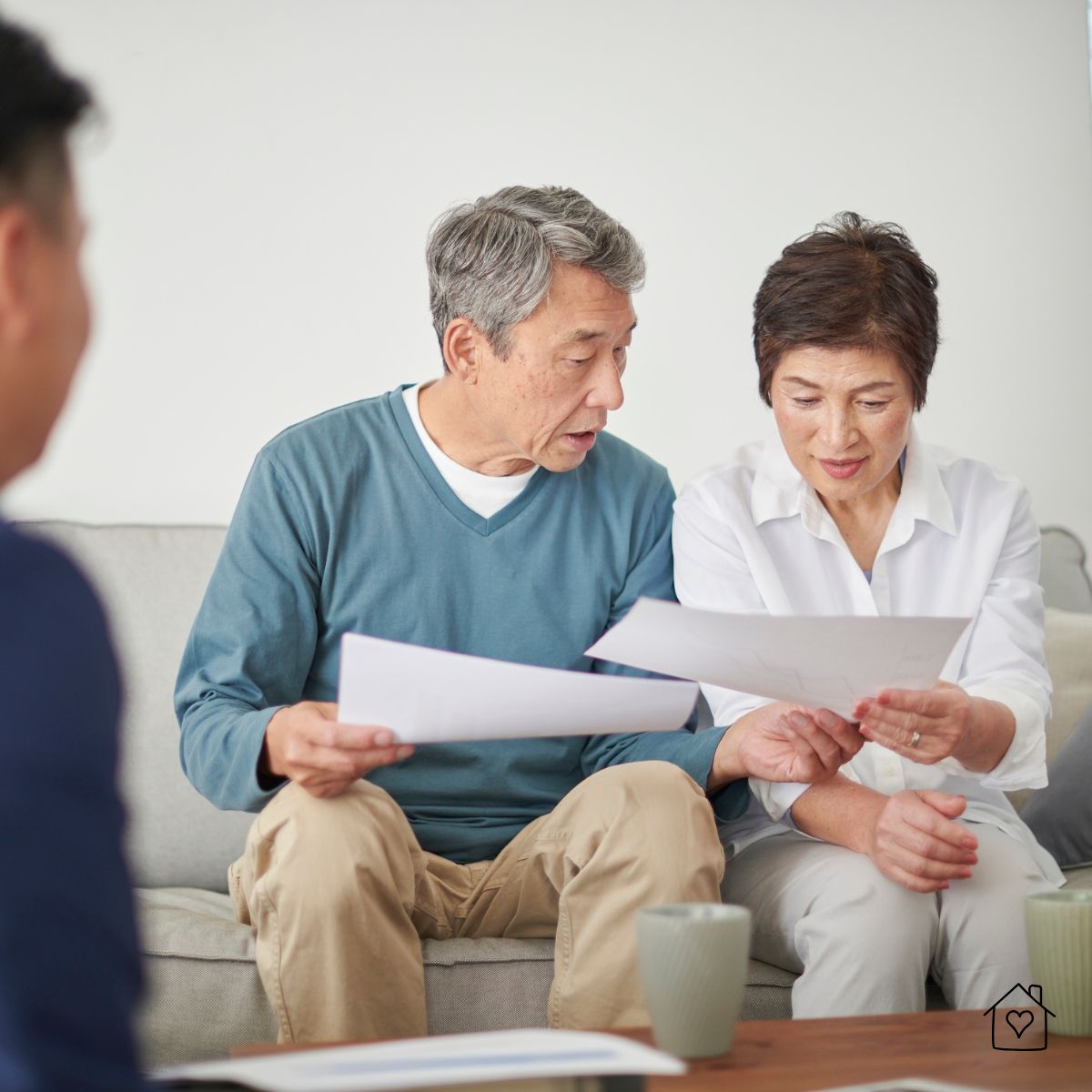 Homeowners reviewing basement waterproofing quotes and warranty details with a contractor to choose the right service.