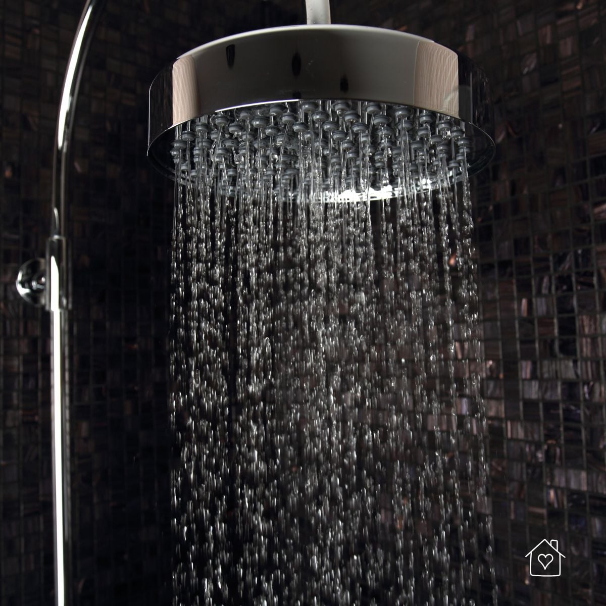 Modern rainfall showerhead running, showing strong flow from a low-flow fixture that saves water without sacrificing comfort.