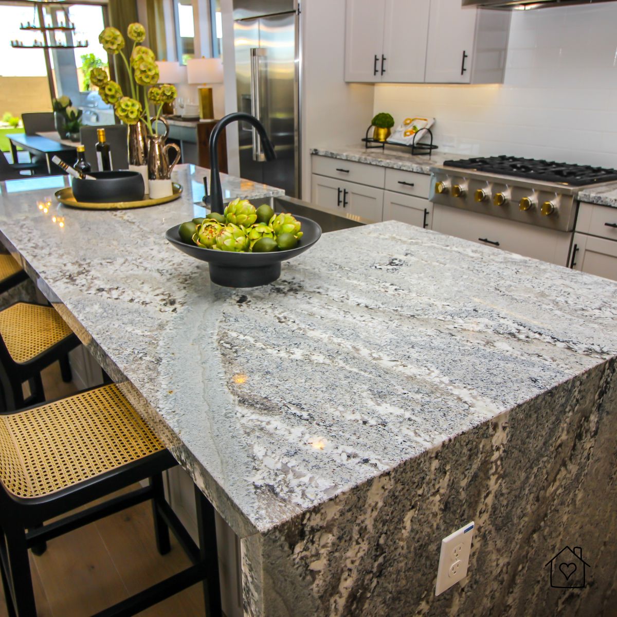 Elegant Chicago kitchen with a large granite island featuring bold veining, black fixtures, and modern seating, creating an architectural focal point.