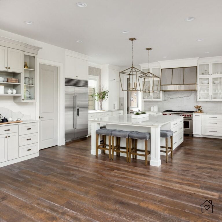 Bright kitchen with white cabinetry, pendant lighting, and dark-stained hardwood floors freshly refinished.