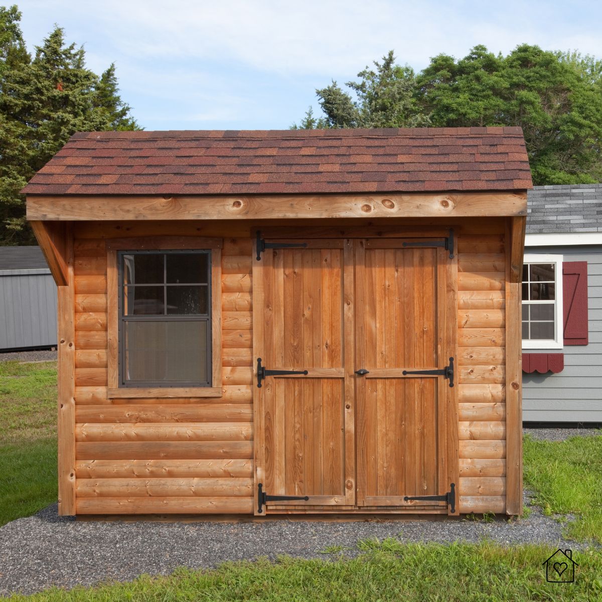 Small cedar storage shed with double doors and window, shown in a backyard—ideal for moving seasonal décor and gear outdoors.