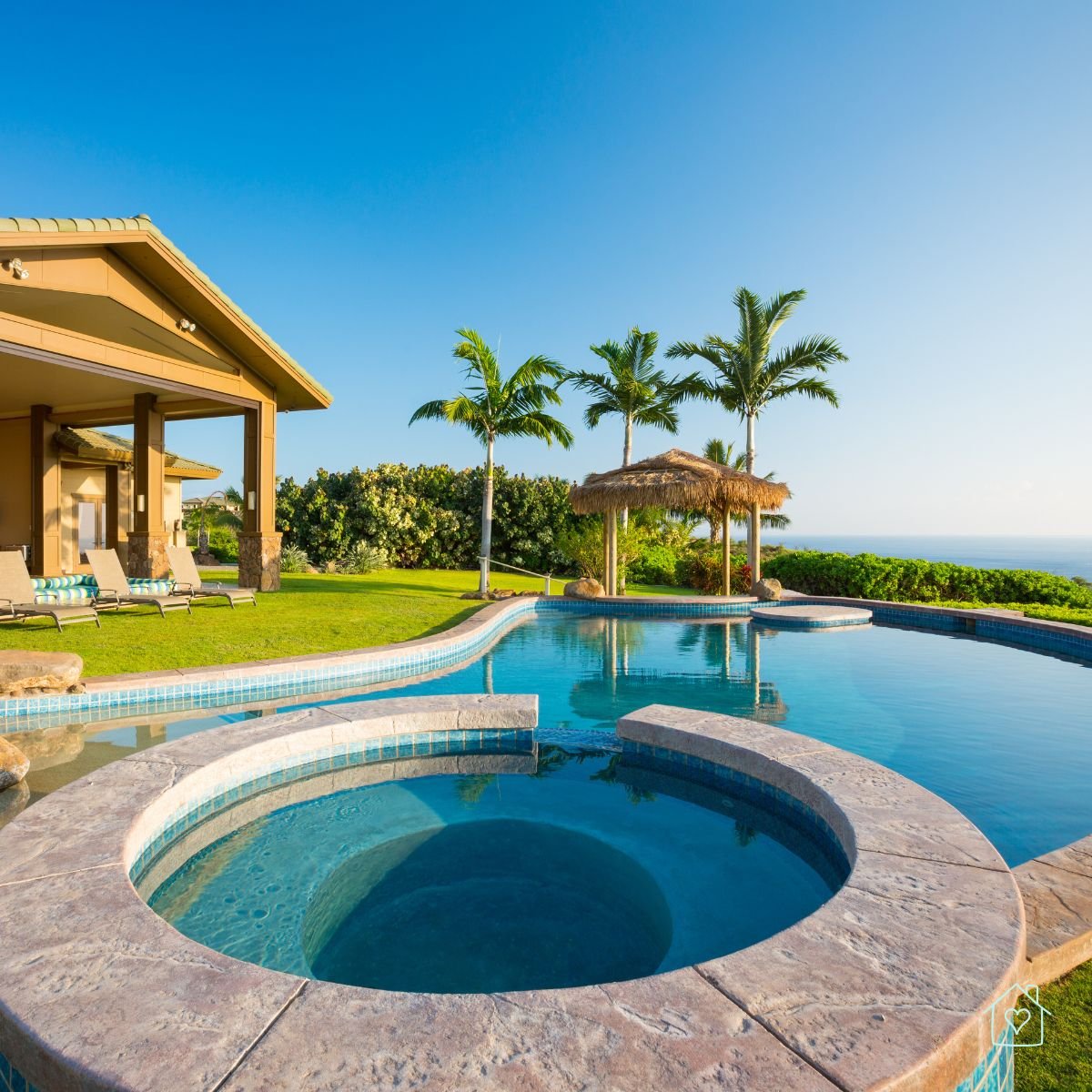 Resort-style pool overlooking the ocean with palm trees and spa area, symbolizing relaxation and easy living.