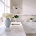 Bright white kitchen with large windows, marble counters, and minimal decor, highlighting smart design that lets natural light fill the room.