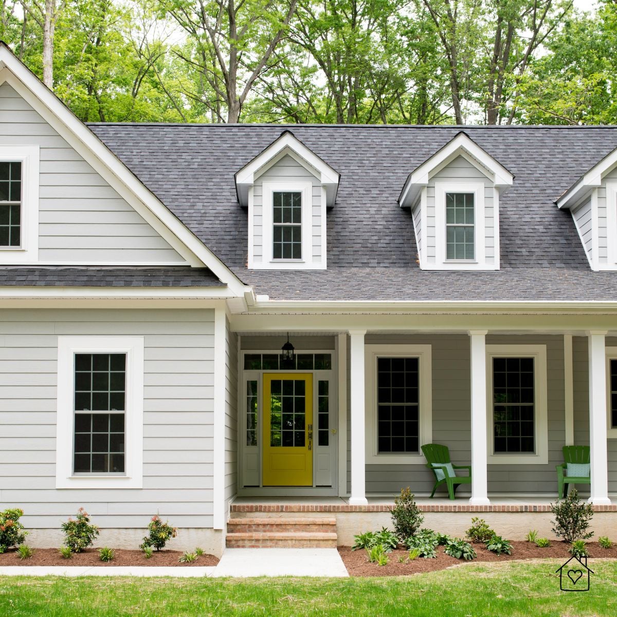 Finished single-storey home with grey cladding, dormers, and a bright yellow front door.Placement: Final image at the end of the post above the closing CTA.