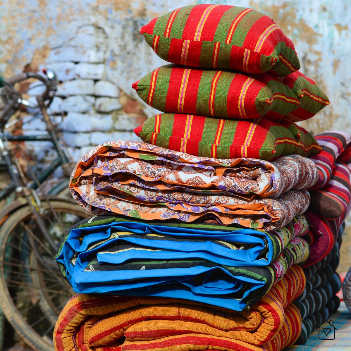 Neatly stacked outdoor cushions and folded quilts ready to be stored between seasons.
