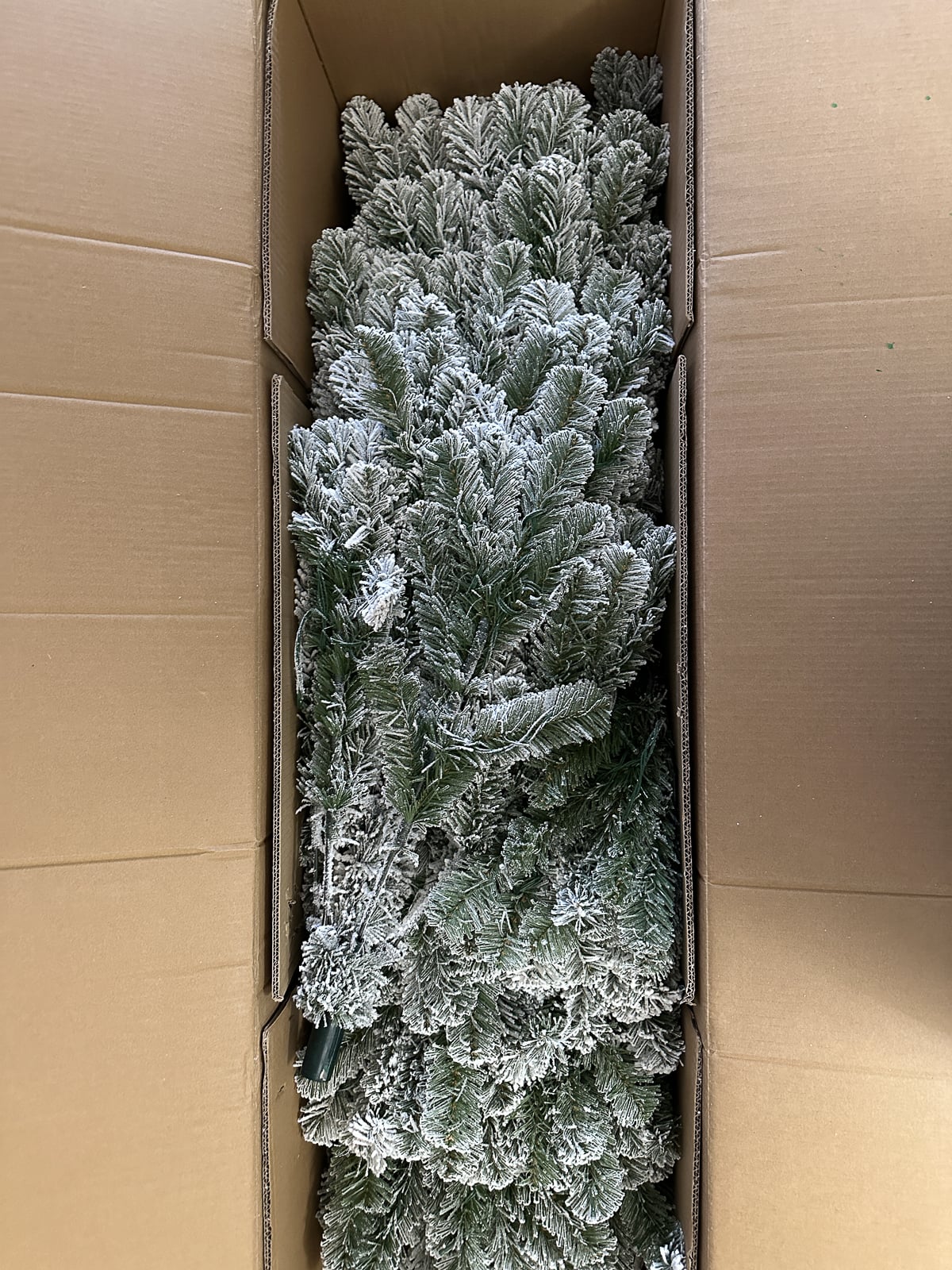 Flocked tree sections neatly packed inside the shipping box.